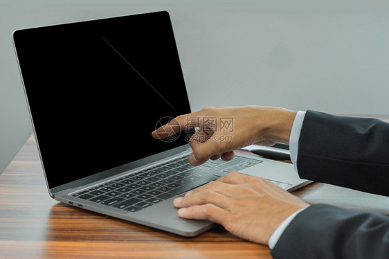 在办公室工作的键盘计算机商人使用电脑笔记本在屏幕上看的电脑笔记本无线的金融网络图片