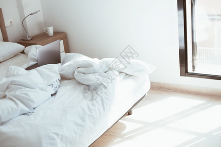 现代公寓有阳光和最起码的设计在大流行病中保持安全在无人制床铺舒适和的偏远家用办公室使手提式电脑现代化公寓提供日光和最起码的设计简图片