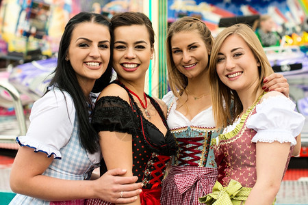 女在德国FunfairOktoberfest和传统的dirndl服装和喜乐节上两个非常典型的德语女孩一个是亚裔和高加索混血儿一个图片