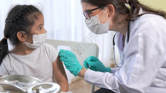 给生病的孩子手臂注射疫苗的女医生图片