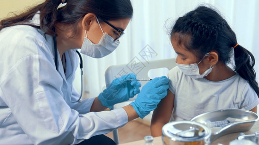给孩子手臂注射疫苗的医生图片
