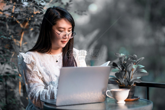 潮人商业女用笔记本电脑和咖啡杯及智能手机在咖啡店商业生活方式做零用笔记的散工在网吧写作快乐的图片