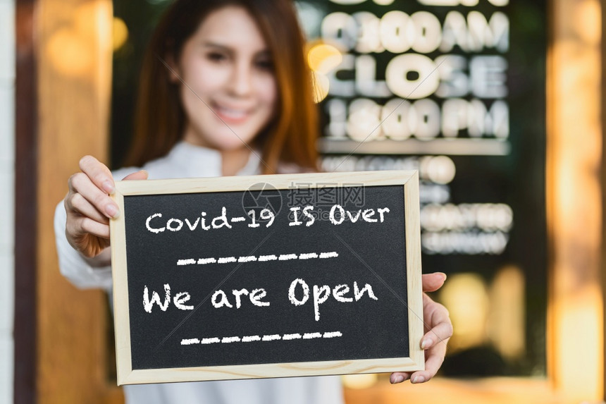 门新冠超过小企业主握着手用Covid19的文字向黑板展示Covid19已经结束我们在咖啡店前是开放牌子在Covid走了之后又恢复图片