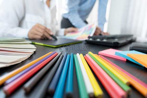 20多岁女商人使用彩色观察编辑艺术作品的图片设计小组在创意办公室工作在桌上用平板牌和图案编辑白种人图片