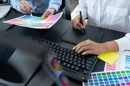 艺术品技使用彩色观察编辑艺术作品的图片设计小组在创意办公室工作在桌上用平板牌和图案编辑图片