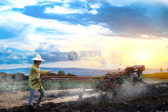 农场播种中耕机利用步行拖拉在美丽的天云下雨并在泰国农村边山上晒太阳用步行拖拉机耕种稻田植水作物泰国农村一带的山顶是美丽天空云和日图片