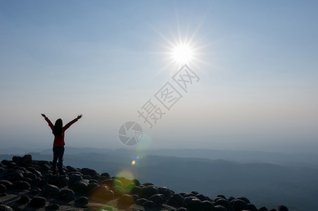 轮廓旋钮夏天日落时站在山顶悬崖上的年轻女子休光月亮享受着对空石头地自然观的看法PhuHinRinRongKla公园山悬崖上的领导图片
