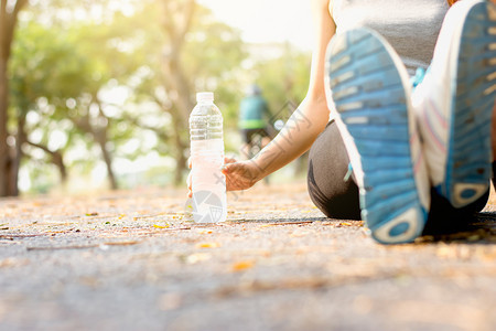 早晨该健身女坐在公园街道上健身和康概念上捡到一瓶水体操和健康概念身体平静的图片
