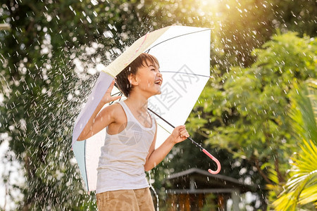 在户外享受雨水的小男孩图片