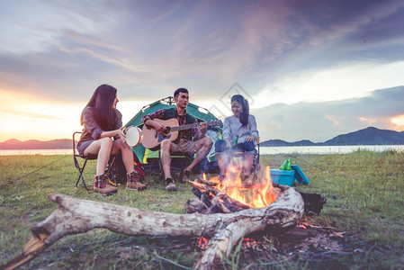 一群旅行者起露营野餐和演奏音乐图片