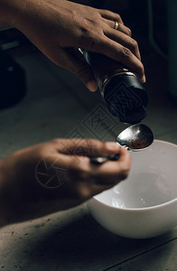 将即时咖啡粉测量成碗握着女股的勺子准备冲入泡沫制造达尔戈纳咖啡自制女士早餐图片