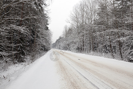 一种照片拍摄于雪下从车道的铁轨表面拍下在雪的冬季路面上拍摄这张照片在雪下消失旅行图片