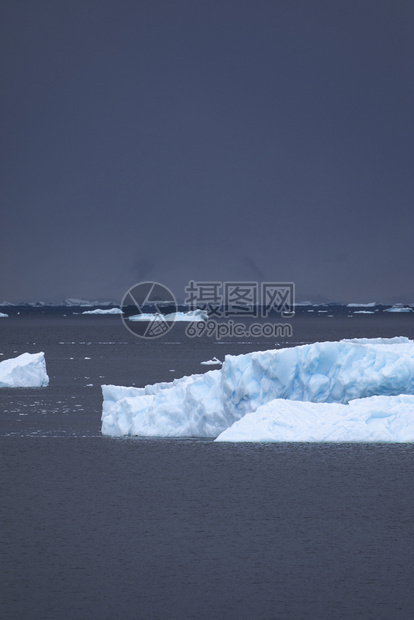 发光宽度浮蓝的冰山在海中游向黑暗的云墙偏蓝图片
