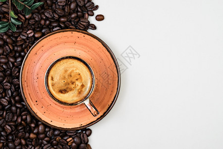 享受平坦的意大利语咖啡杯和烤豆在灰色背景的咖啡面上馆杯中的香果奶油带有文本复制空间的模板图片