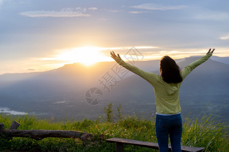 自由旅行者十几岁青少年在黄夕美丽的PhuPaPO或泰国的FujiLoei怀着举起的手站在蓝天边假期女士图片