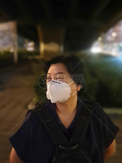 亚洲妇女使用面罩N95呼吸保护面罩对抗空气其烟雾PM25粉尘超过曼谷市的标准值在曼谷的公路交通中造成恶劣天气空污染而曼谷妇女则使图片