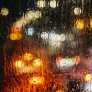 情绪忧郁的抽象背景与散焦的灯光景在英国伦敦窗玻璃的雨滴后面由于景深较浅专注于几滴在英国伦敦散焦的灯光景情感忧郁抽象背景在窗玻璃的图片