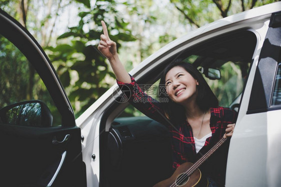 音乐与白色汽车的Ukulele一起在户外夏季与Ekule一起挑逗和玩乐的亚洲美容女旅行摄影家Histster风格的概念和Solo图片