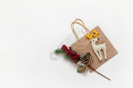 传统的项目快乐金黄色圣诞礼物袋白色的有黄角玩具鹿红莓和白背景针头的红色树枝复制空间节日新年销售购物概念平面观图片