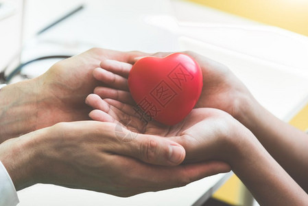 希望人类医生手握着红按摩心脏并给予患病的幼儿红按摩心脏以便他们从疾病医院和保健护理概念中康复心肺病和脏后预防艾滋和心脏爱捐赠健康图片