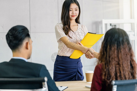 亚洲人积极的成功年轻亚洲女毕业生与两名经理握手在开始面试前欢迎两位经理在会议室进行积极动的工作面试Business雇用新会员Jo图片