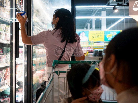 201年7月日母亲在冰箱中选择新鲜奶制品或酸她的两个年轻女儿坐在清迈购物超市的车里以健康为目的医疗饮食闲暇图片