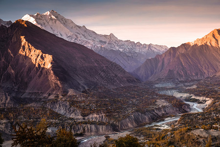 著名的云环境巴基斯坦卡拉科姆山脉卡波希峰的雪冠上照亮晨光吉尔特俾提斯坦秋天Hunza河和森林树木也随之而来图片