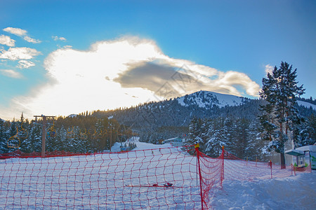 越野寒冷的具有山脉森林红色保护栅栏形成长方状的红护栏和吉尔斯坦公园背景下雪顶峰的高山风景红防护栅栏景区图片