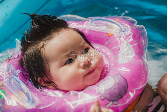 可爱女婴套着泳圈游泳图片
