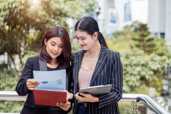 两名年轻的亚洲女企业家他们研究文件档案夹以分析在推销之后的利润或售突破点然后分析利润或销售中断点商业团队合作雇员与工妇女的生活方图片