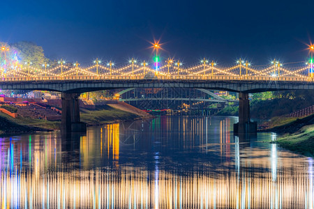 夜晚南河上美丽的灯光晚上在奈里川大桥的宁在泰国菲特萨努洛克举行的大节和红十字年度活动反射交通图片