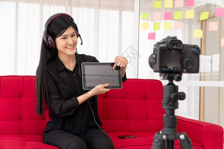 冠状女士VlogAsia女博客影响者坐在沙地上并录制视频博客用于教学辅导生或订阅者如何在网上创作新生活方式内容的概念学生们图片