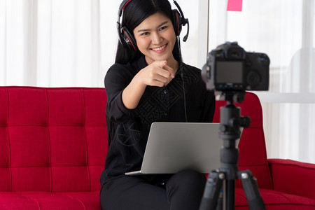 电话教程VlogAsia女博客影响者坐在沙地上并录制视频博客用于教学辅导生或订阅者如何在网上创作新生活方式内容的概念技术图片