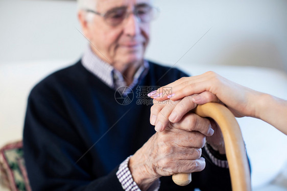 过程甘蔗由女健康访客慰藉的不快乐老年男子举手走着棍棒行水平的图片