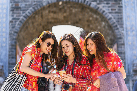 老的在利江城旅行时利用智能手机一起使用社交网络的智能手机旅游和友爱观概念的3个亚洲幸福妇女肖像穿越里江老城旅行和游风景优美城市图片