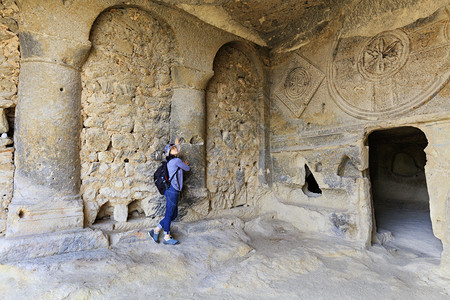 结石卡帕多西亚一个古老董地下教堂由沙石雕塑的地下教堂在Capapadocia的一个年轻女子检查了旧地下教堂圆的内侧雕刻在一座沙石图片