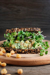 开胃菜晚餐损失黑麦面包三明治和片加粉碎的鳄梨小鸡豆和萝卜芽葡萄干对于关注健康和素食者来说这是一个好主意图片