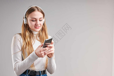 溪流媒体可爱的年轻女孩聆听音乐流内容于观看视频享受聊天与朋友使用