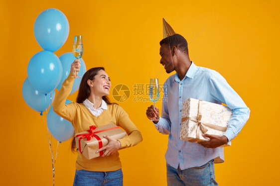 女孩oopicapi年轻的装着饮料和礼品盒杯子的可笑夫妇黄色背景漂亮女得到惊喜活动或生日庆典气球装饰带饮料杯子的有趣夫妇彩虹装饰图片