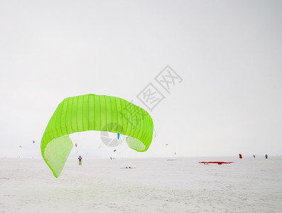 存在冰Kite冲浪手被他的风筝拉扯穿过雪中滑板车和上风筝经过图片
