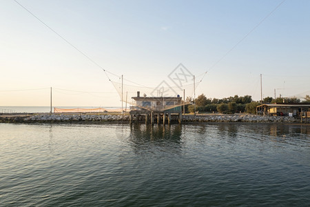 靠近沿河捕鱼小屋的景观和典型意大利式捕鱼机称为TrabuccoLidodiDanteComacchio山谷附近的FiumiUni图片