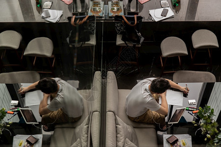 在职的泰国曼谷204年7月日20年月日一名年轻人在共同工作空间的黑桌上工作或在线学习的顶层视野数字游牧民在共同工作空间现代信息技图片