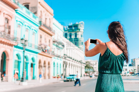 文化微笑哈瓦那街上的女人古巴年轻女旅行者在哈瓦那流行地区带着著名的观光女游客fotoFoto古巴的年轻女旅行者笑得开心目的地图片