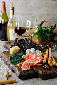 开胃菜木板上的安提帕斯托Antipasto配有香菜不同种类的奶酪葡萄和无花果子格里西尼帕尔马图片