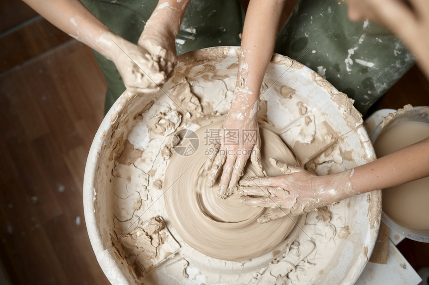 车轮男生手工业儿童在讲习班的陶艺者股轮上工作手顶高视距Clay在艺术学校做模范课青年民间工艺大师爱好童年快乐儿在陶艺者股轮上工作图片