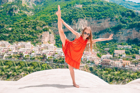 晴天Amalfi海岸屋顶上可爱的小女孩在意大利波西塔诺镇温暖阳光明媚的夏日目睹欧洲老城背景中可爱的小姑娘在意大利波西塔诺镇温暖和图片