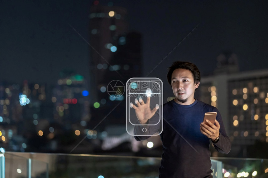 个人电脑亚洲创意自由职业者使用智能手机在泰国Bangkok河边金融区使用指纹授权的智能移动电话具有职业概念的技术亚洲创造自由职业图片