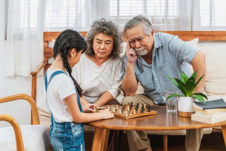 采用亚洲人严肃的夫妇有孙子祖父和女一起下棋共同思考支持和成功长寿老年人社会温暖家庭和幸福社会失常概念温室家庭与幸福图片