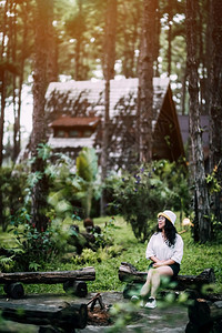 环境在泰国清迈县DoiBoLuang森林公园自然足迹上的松树林木小屋绿中身着白衣戴帽子的亚洲女观光游客站立在松树小屋内白色的旅游图片
