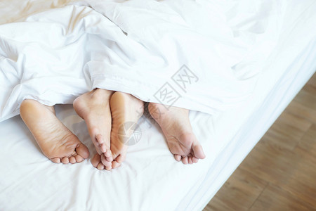 人们皮肤两对情侣并肩睡在一起坐被毛毯白色床单下躺在家中的床上假期概念有浪漫时刻的爱光留下写文字的空间副本女图片